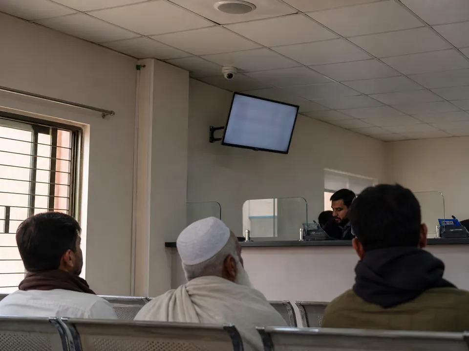 Queue display and ceiling speaker above a calm waiting area