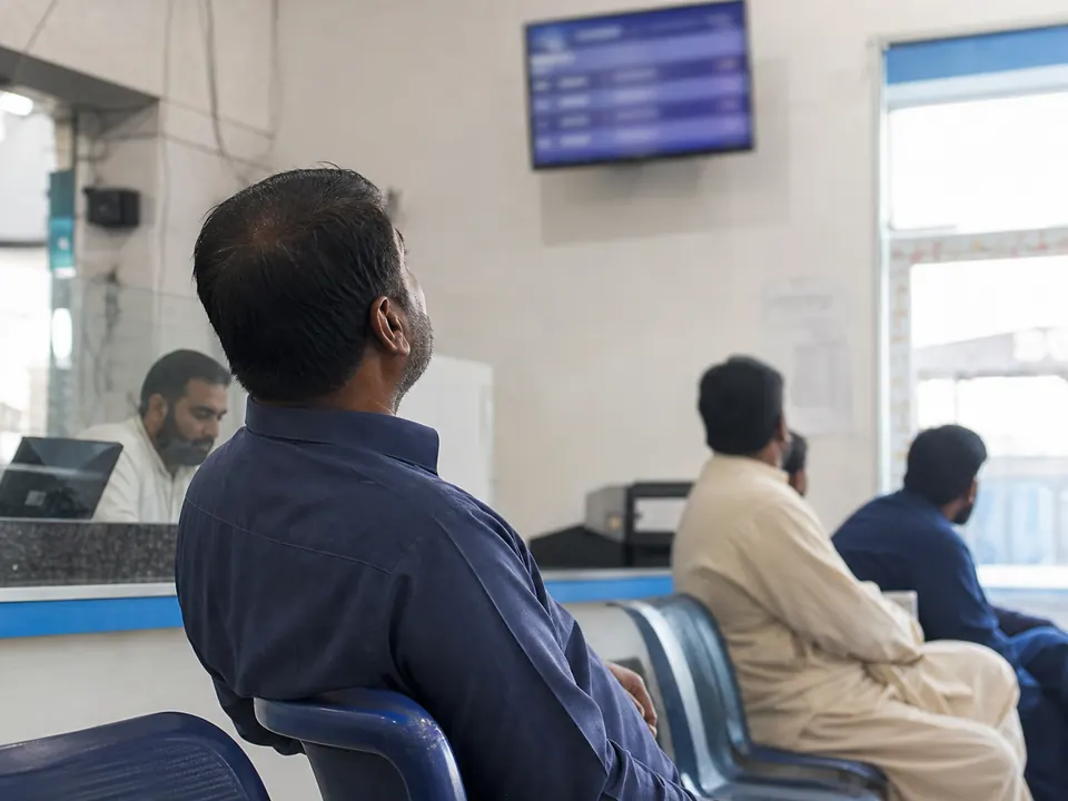 Seated customers watching a queue display for the next turn